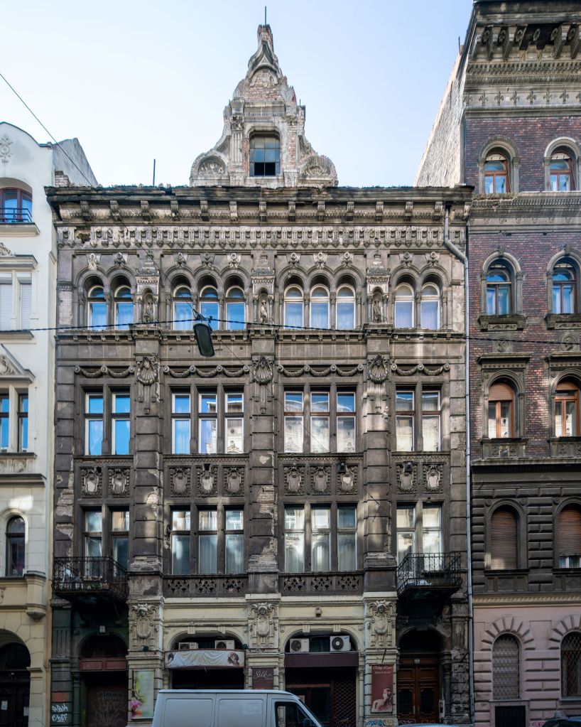 Facade of a decaying building in Budapest designed by the famous architect Lipót Baumhorn